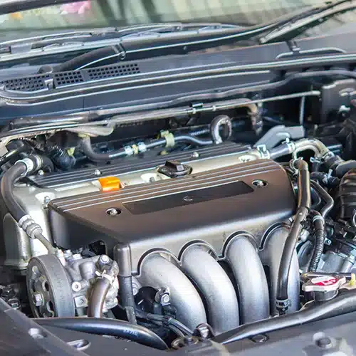 Close-Up View of a Modern Car Engine Detailed view of a clean, modern car engine with visible components like intake manifold, exhaust, and wiring.