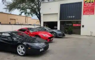 Classic and Modern Ferrari Sports Cars at JFM Motorcars Dealership Black Ferrari Testarossa, red F12berlinetta, and grey Ferrari parked outside JFM Motorcars in Palm Beaches.
