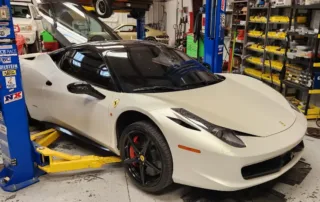 White Ferrari on Car Lift in Garage White Ferrari on a car lift in a garage with tools and equipment