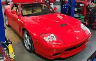 Red Ferrari Sports Car in Garage Red Ferrari sports car parked in a garage with tools and equipment