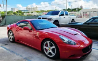 Red Ferrari Parked in Lot with White Truck Red Ferrari sports car parked in lot with white truck and black car