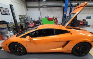 Orange Lamborghini in Garage with Hood Open Orange Lamborghini sports car in a garage with hood open