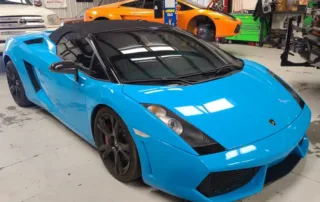 Blue Lamborghini Convertible in Garage with Orange Sports Car Blue Lamborghini convertible parked in garage with orange sports car