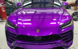 Purple Lamborghini in Garage with Black Grille Front view of a purple Lamborghini with black grille in a garage