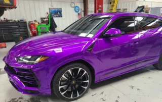 Purple Lamborghini SUV in Garage Purple Lamborghini SUV parked in a garage with tools and equipment