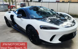 White Sports Car at JFM Motorcars in West Palm Beach Sleek white sports car with black accents parked on concrete