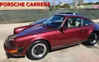 Classic Red Porsche Carrera Coupe A gleaming red classic Porsche Carrera coupe with black rims parked outdoors.