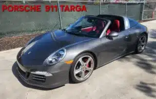 Porsche 911 Targa: A Stylish Gray Sports Car A sleek, gray Porsche 911 Targa with red interior parked on a concrete surface.
